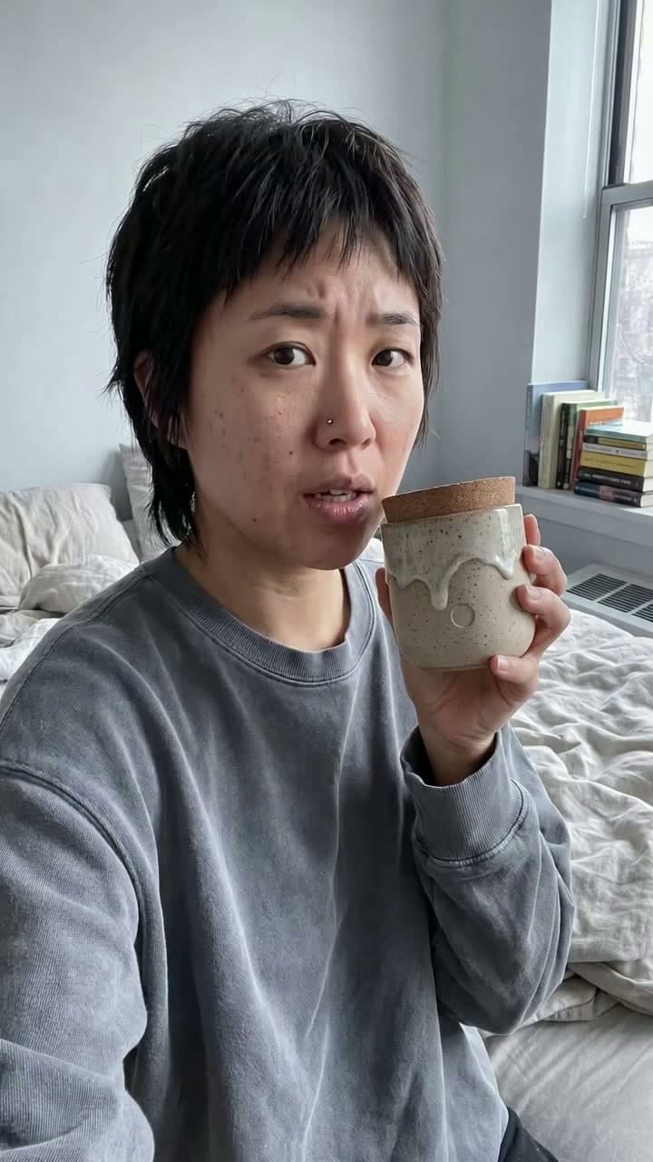 A woman talking about a candle she holds, from one photo