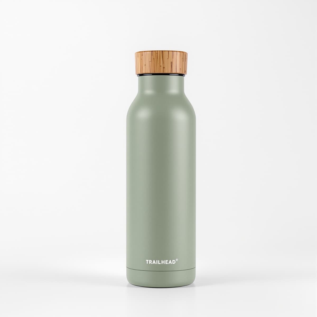 A sage green steel water bottle with a bamboo lid on a white background